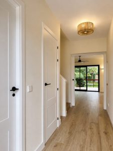 Entrada con puertas lacadas en blanco – reforma integral de chalet en Torrelodones