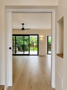 Paso al salón con vistas al jardín – reforma integral de chalet en Torrelodones