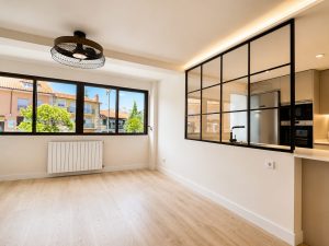 Salón con cerramiento de acero y vidrio hacia la cocina – reforma integral de vivienda en Torrelodones