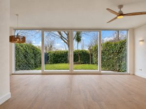 Salón reformado con gran ventanal al jardín, chalet adosado en Alcobendas