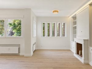 Salón con chimenea y librerías lacadas – reforma integral de piso en Madrid