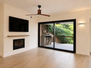Salón con chimenea y ventanal al jardín – reforma integral de chalet en Torrelodones