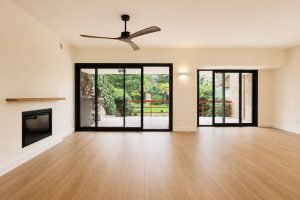 Salón con chimenea y ventanal al jardín – reforma integral de chalet en Torrelodones