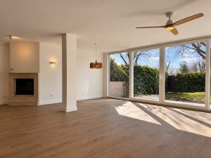 Vista general del salón con chimenea y suelo de madera, reforma integral en Alcobendas