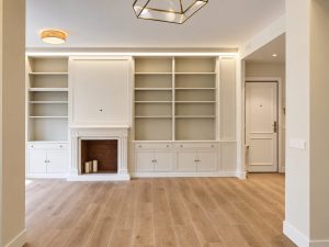 Salón con chimenea y librerías lacadas – reforma integral de piso en Madrid
