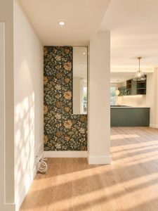 Entrada con papel pintado de flores – reforma integral de piso en Madrid