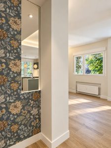 Entrada con papel pintado de flores – reforma integral de piso en Madrid