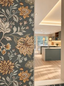 Entrada con papel pintado de flores – reforma integral de piso en Madrid
