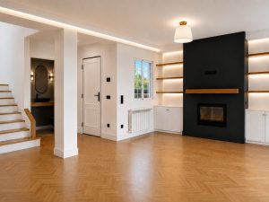 Chimenea negra con estanterías de roble iluminadas en el salón · reforma integral en Torrelodones