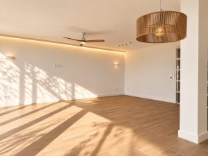Salón con tira LED perimetral en techo y lámpara colgante, reforma en Alcobendas