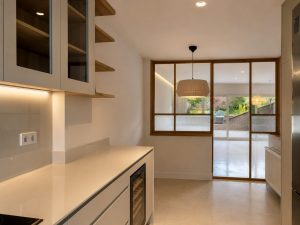 Cocina con encimera en cascada – reforma integral en Torrelodones