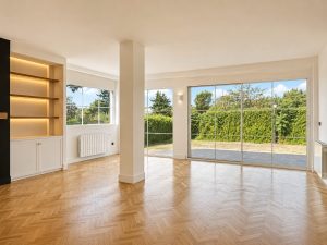 Chimenea negra con estanterías de roble iluminadas en el salón · reforma integral en Torrelodones
