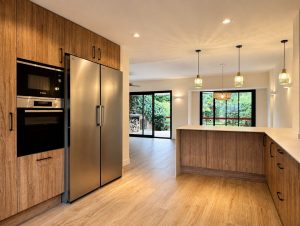 Cocina de madera con encimera porcelánica blanca – reforma integral de chalet en Torrelodones
