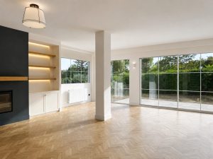 Chimenea negra con estanterías de roble iluminadas en el salón · reforma integral en Torrelodones