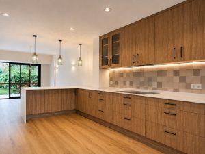 Cocina de madera con encimera porcelánica blanca – reforma integral de chalet en Torrelodones