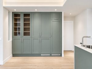 Cocina verde salvia con península blanca – reforma integral de piso en Madrid