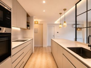 Cocina con península y encimera Laminam – reforma integral de vivienda en Torrelodones