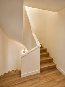 Escalera revestida en porcelánico efecto madera – reforma integral de chalet en Torrelodones