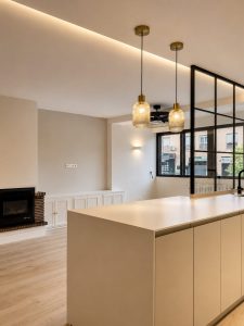 Cocina con península y encimera Laminam – reforma integral de vivienda en Torrelodones