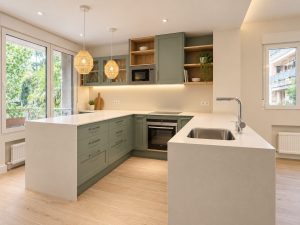 Cocina verde salvia con península blanca – reforma integral de piso en Madrid