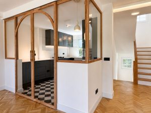 Cocina azul oscuro con suelo ajedrezado y cerramiento de roble con arcos · reforma integral en Torrelodones