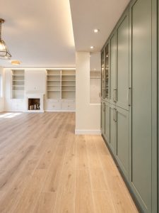 Cocina verde salvia con península blanca – reforma integral de piso en Madrid
