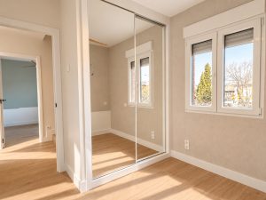 Dormitorio con armario de espejo y acceso a pasillo, chalet reformado en Alcobendas