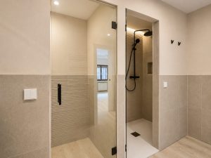 Baño principal con doble lavabo y mueble de madera – reforma integral de vivienda en Torrelodones