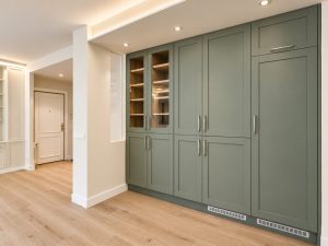 Cocina verde salvia con península blanca – reforma integral de piso en Madrid