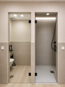 Baño principal con doble lavabo y mueble de madera – reforma integral de vivienda en Torrelodones