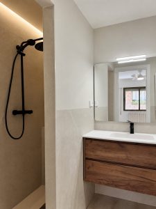 Baño de invitados con grifería negra – reforma integral de vivienda en Torrelodones