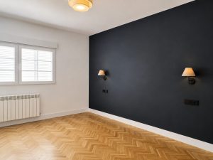 Dormitorio principal con pared azul oscuro y apliques de lectura · reforma integral en Torrelodones