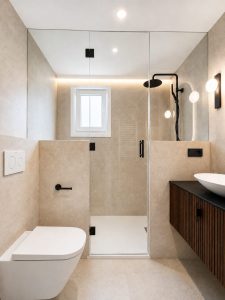 Baño principal con plato de ducha amplio y grifería negra · reforma integral en Torrelodones